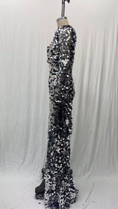 Détail de paillettes argentées scintillantes sur une robe de soirée à manches longues