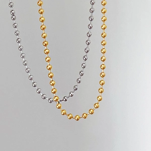 Detailed macro shot of gold and silver plated ball chain necklaces with metallic finish