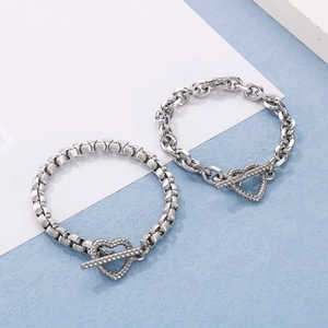 Detail of silver double-layered chain bracelets with heart-shaped T-bar toggle clasp