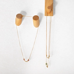 Detail of gold chain necklace featuring colorful dual heart pendants and adjustable link