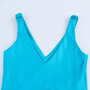 Detail of teal satin dress showing V-neckline and elegant pleated shoulder strap textures