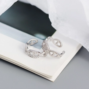 Detail view of silver chain link ear cuff with sparkling rhinestones on soft fabric