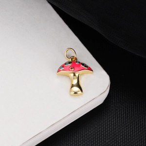 Detail of red enamel mushroom pendant with colorful crystals and 18K gold plating