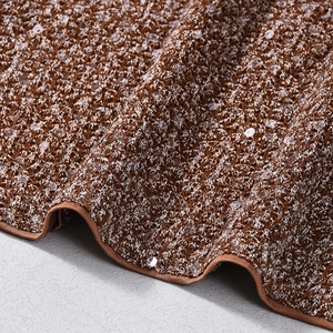 Gros plan sur un tissu en maille marron avec paillettes brillantes et tissage texturé