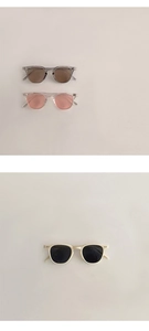Détail de trois lunettes de soleil pour enfants en gris transparent rose et crème