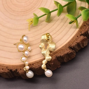Handcrafted irregular gold streaming earrings with natural white freshwater pearls on wood