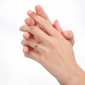 Detail of 6mm polished 18K gold stainless steel band ring on model's finger
