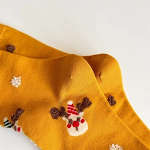 Detail of soft ginger knitted cotton sock featuring a cute Christmas reindeer and dots