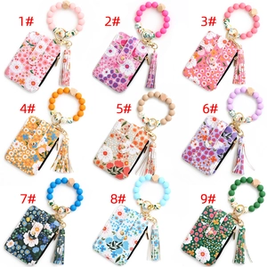 Collection of nine floral print card holders with silicone bead bracelets and tassels