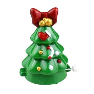 Wind-up walking green Christmas tree toy with red bow and gold bells on white background