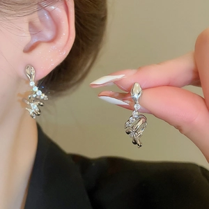 Detail of silver snake-shaped C-stud earrings with sparkling cubic zirconia rhinestones