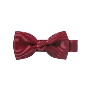 Détail du nœud papillon en ruban gros-grain rouge foncé avec texture de tissu côtelé