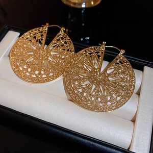 Detailed view of vintage hollow round gold metal earrings in a jewelry gift box