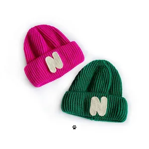 Kids knitted beanies in fuchsia and dark green with vintage N patch and thick texture