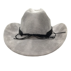 Close-up of woven cowboy hat texture with black decorative band and rope bow detail