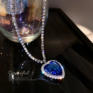 Elegante Herz-Halskette mit blauem Edelstein und Silberkette im dunklen Licht
