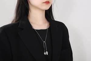 Detail of silver heart and girl pendant on adjustable snake chain worn by a model