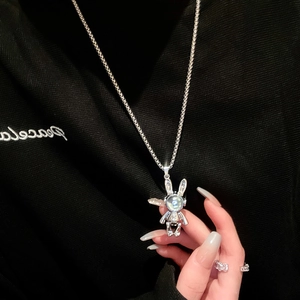 Silver astronaut rabbit pendant necklace with moonstone effect on black hoodie background