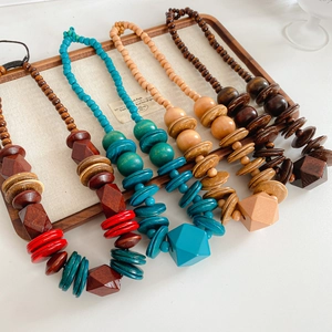 Macro shot of ethnic wooden necklaces with colorful beads on a linen display tray