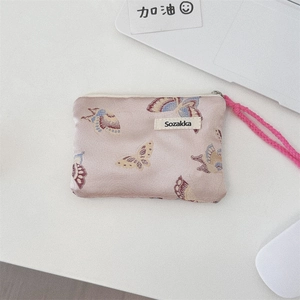 Detail of pink floral jacquard fabric bag featuring colorful butterfly patterns and wrist strap