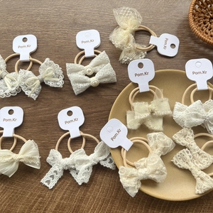 Chic lace bow hair scrunchies set with pearl accents on wooden background