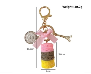 Detailed view of macaron keychain with size and weight info, featuring Eiffel Tower charm
