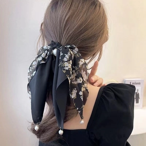 Floral black ribbon hair tie with bow and pearl accents on elegant model ponytail