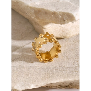 18k gold plated stainless steel ring with white rhinestones and beaded edge on stone surface