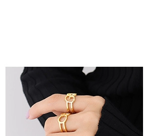 Close-up of gold plated C-shaped hollow ring featuring a geometric G letter motif