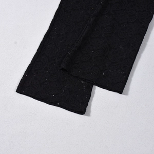 Primer plano de encaje negro con lentejuelas brillantes en un conjunto sexy de dos piezas