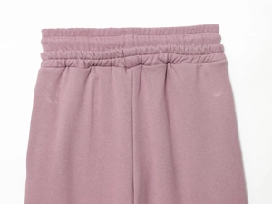 Détail de la taille élastique et des coutures sur le pantalon en maille mauve