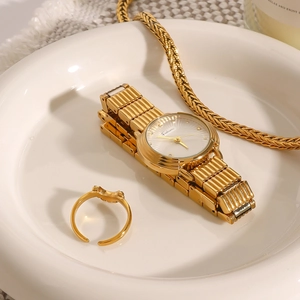 Elegant 18k gold stainless steel watch and ring set on white ceramic tray