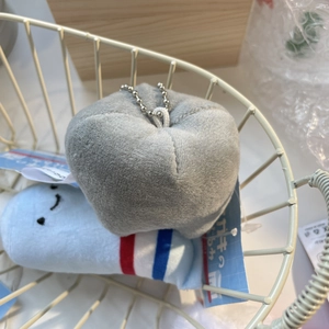 Detail of plush heart and character keychains with metal chains in a white basket