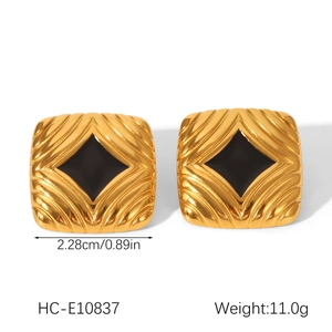 Detail of 18K gold-plated square stud earrings with sunburst texture and black center
