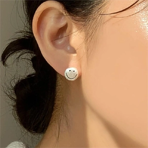 Minimalist 925 sterling silver smiley face stud earrings worn on female ear
