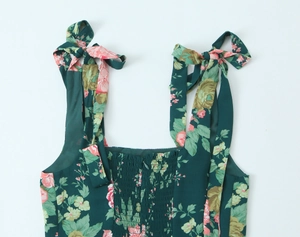 Detail of smocked elastic bodice and tie-up ribbon straps on floral midi dress