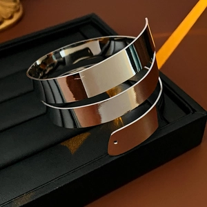 Close-up of a silver polished spiral arm cuff resting on a black jewelry box