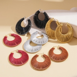 Bohemian woven geometric hoop earrings in multiple colors on minimalist stone props
