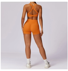 Vista posteriore del reggiseno sportivo arancione con incrocio e pantaloncini fitness