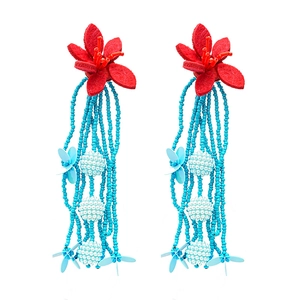 Vibrant beaded flower tassel earrings with red fabric petals and blue bead fringe
