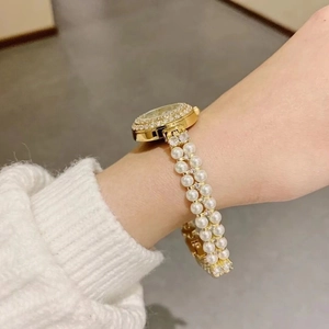 Detail of luxury gold pearl watch band featuring white pearls and sparkling rhinestones