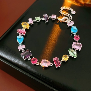 Detail of silver bracelet with multi-colored teardrop and square zircon gemstones