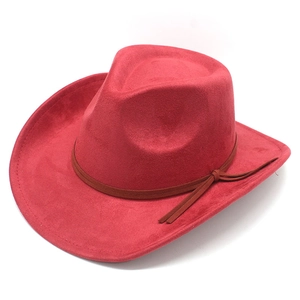 Détail d'un chapeau de cowboy rouge en daim avec une bande décorative à glands