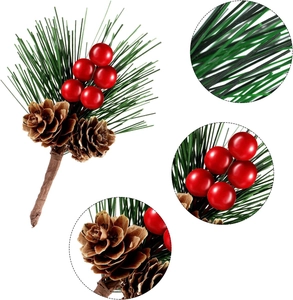 Detail view of artificial Christmas pine needles with red berries and pine cones
