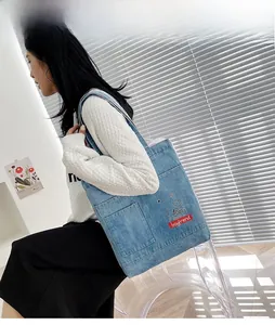 Dettaglio della borsa tote in denim azzurro con ricamo I don't have a boyfriend