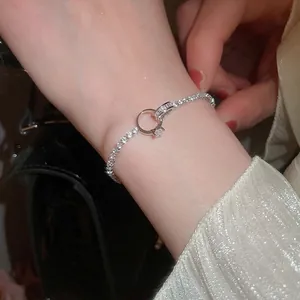 Sparkling silver knotted circle bracelet with zircon accents worn on a female wrist
