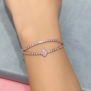 Detailed view of a double-layer pink zircon clover bracelet on a woman wrist