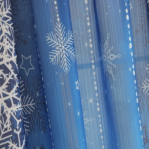 Detailed texture of blue blackout curtains with white snowflake pattern and starry design
