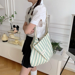 Close-up of a large canvas tote bag with stylish green and white vertical stripes