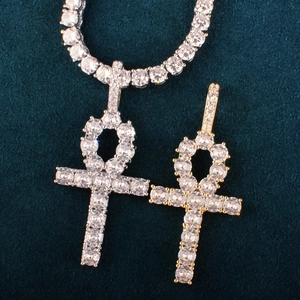 Macro shot of gold and silver Ankh cross pendants with zircon on blue velvet tennis chain